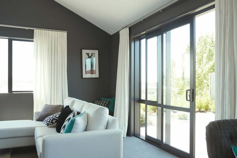 Large aluminium bi-fold sliding doors opening to outdoor patio space by Ali-Frame